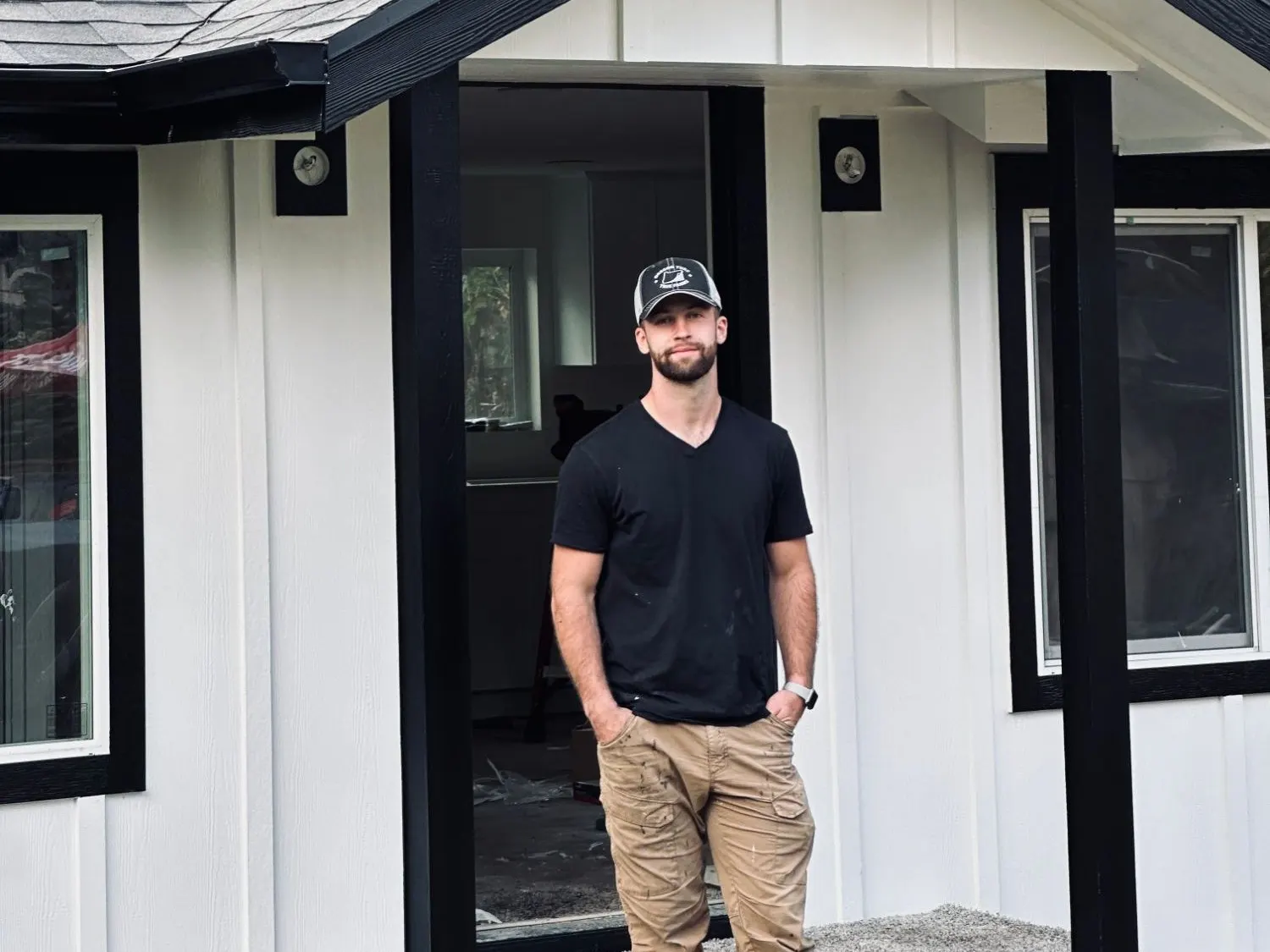 The owner of Fomin Windows & Doors standing on the porch of a finished home