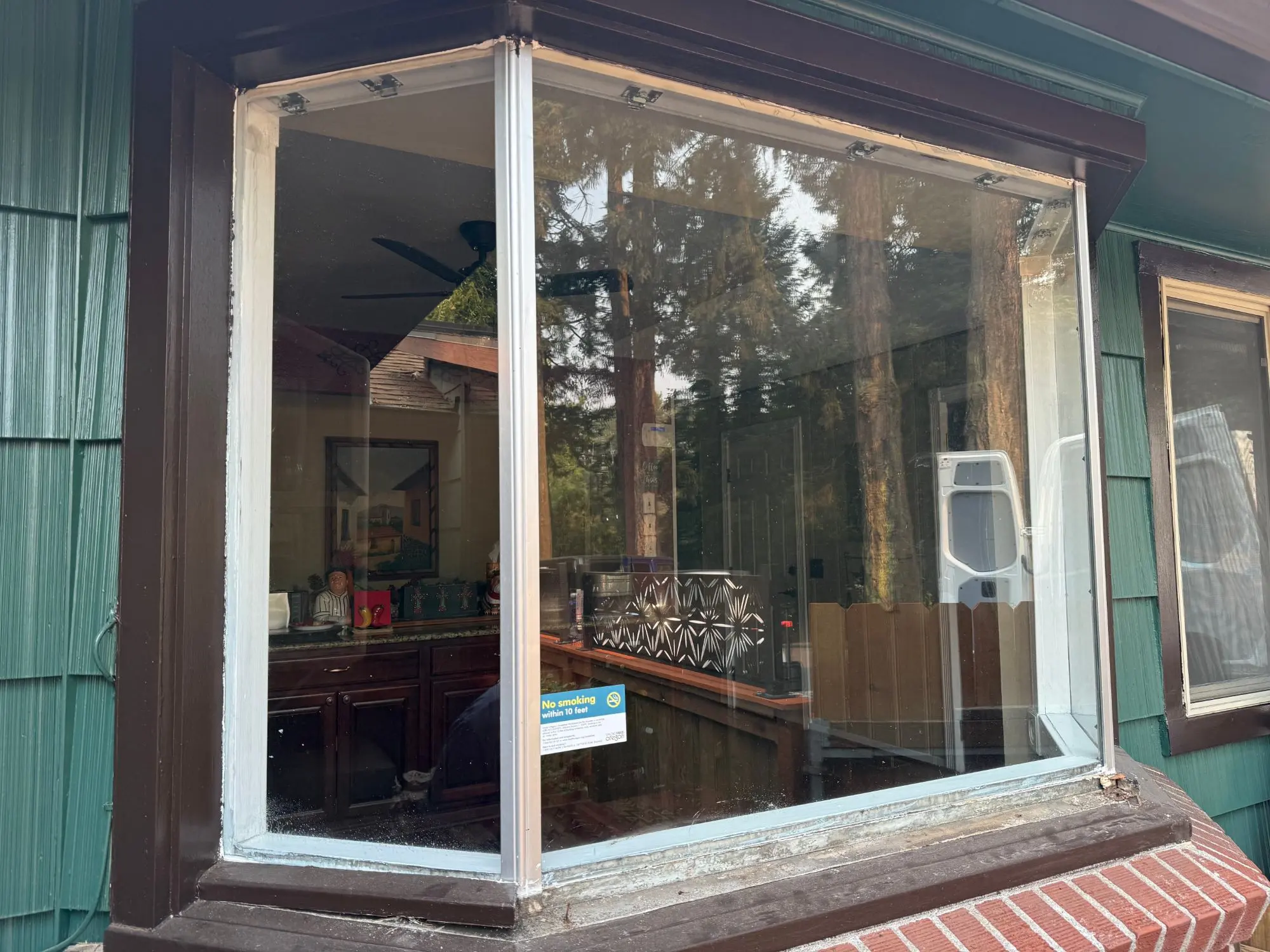 Bay window before replacement, with old aluminum frames and a weathered sill